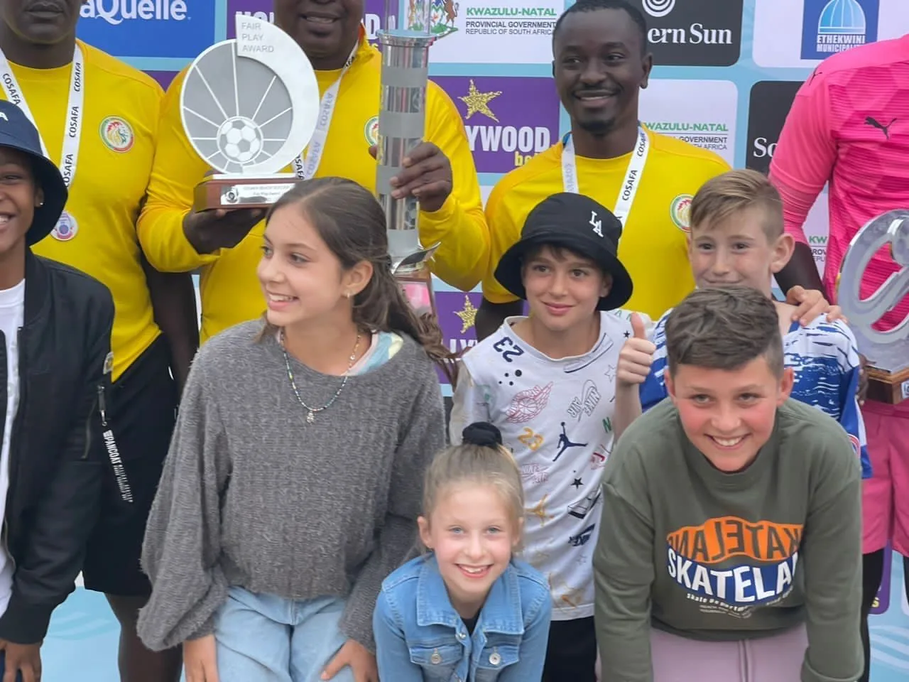 Joueurs sénégalais entourés d’enfants, trophée en main