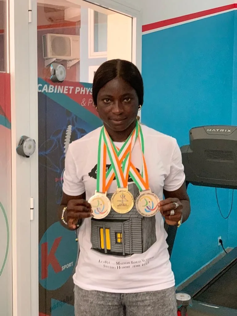 Sportive montrant ses médailles au cabinet K-Sport