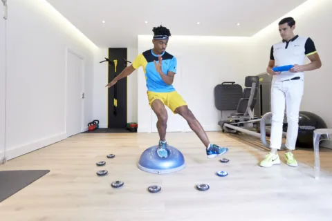 Exercice d’équilibre sur plateau instable pendant une préparation sportive
